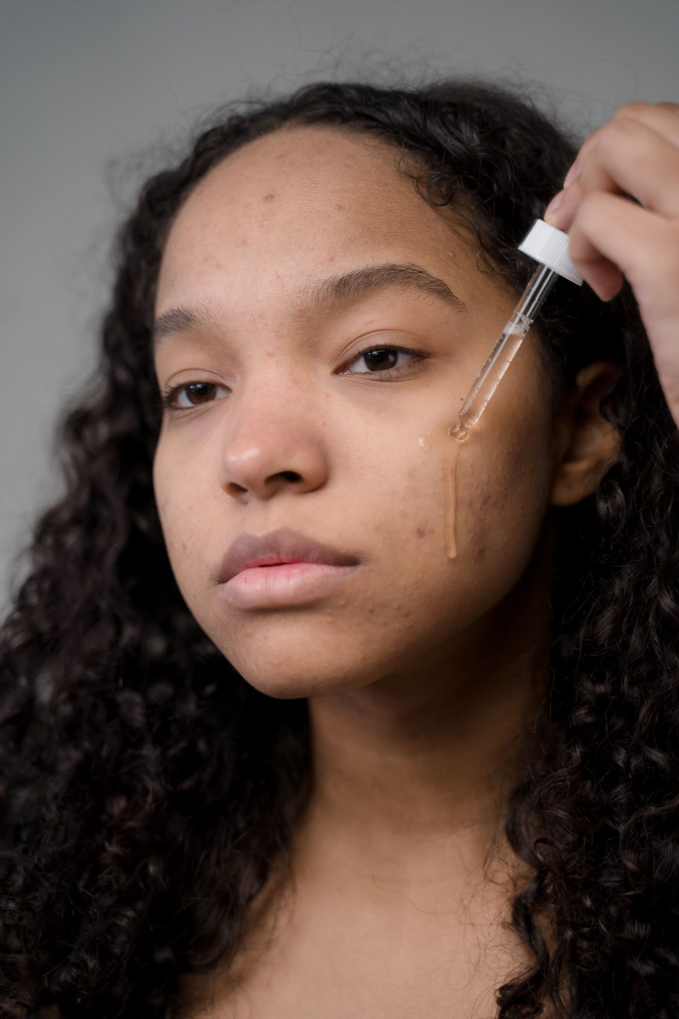 Applying a brightening serum along the cheek