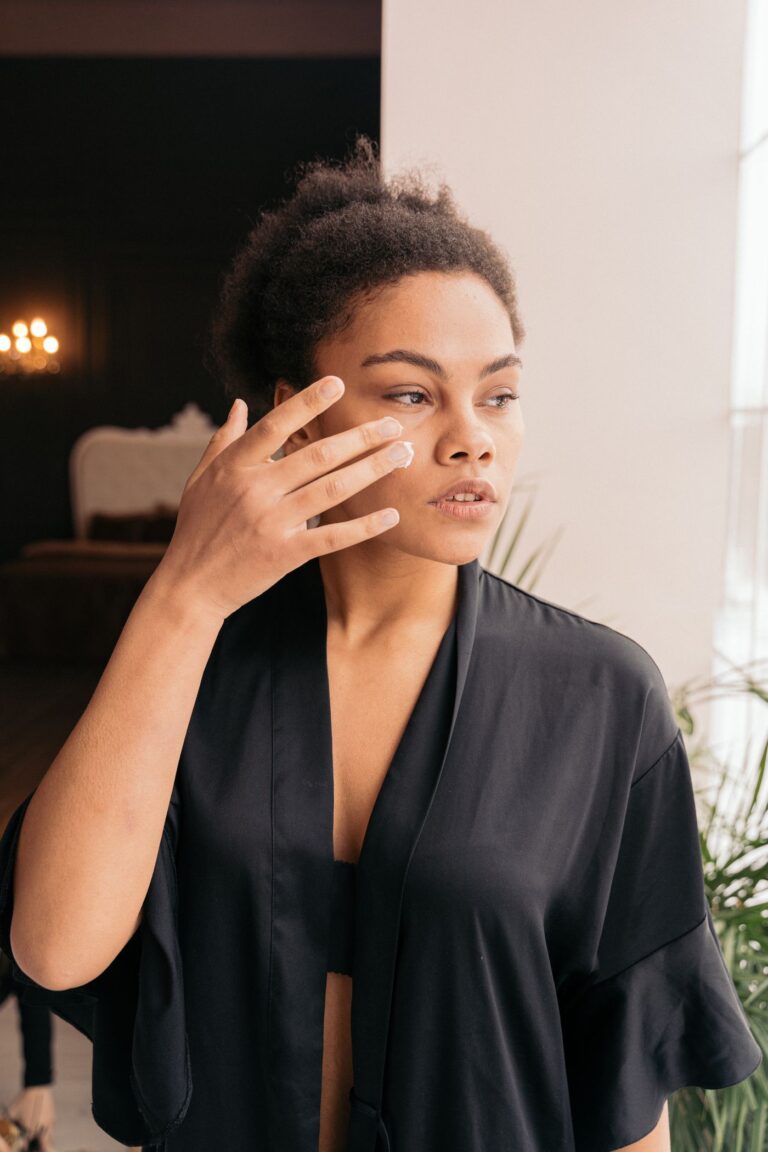 Woman applying moisturiser to her cheek