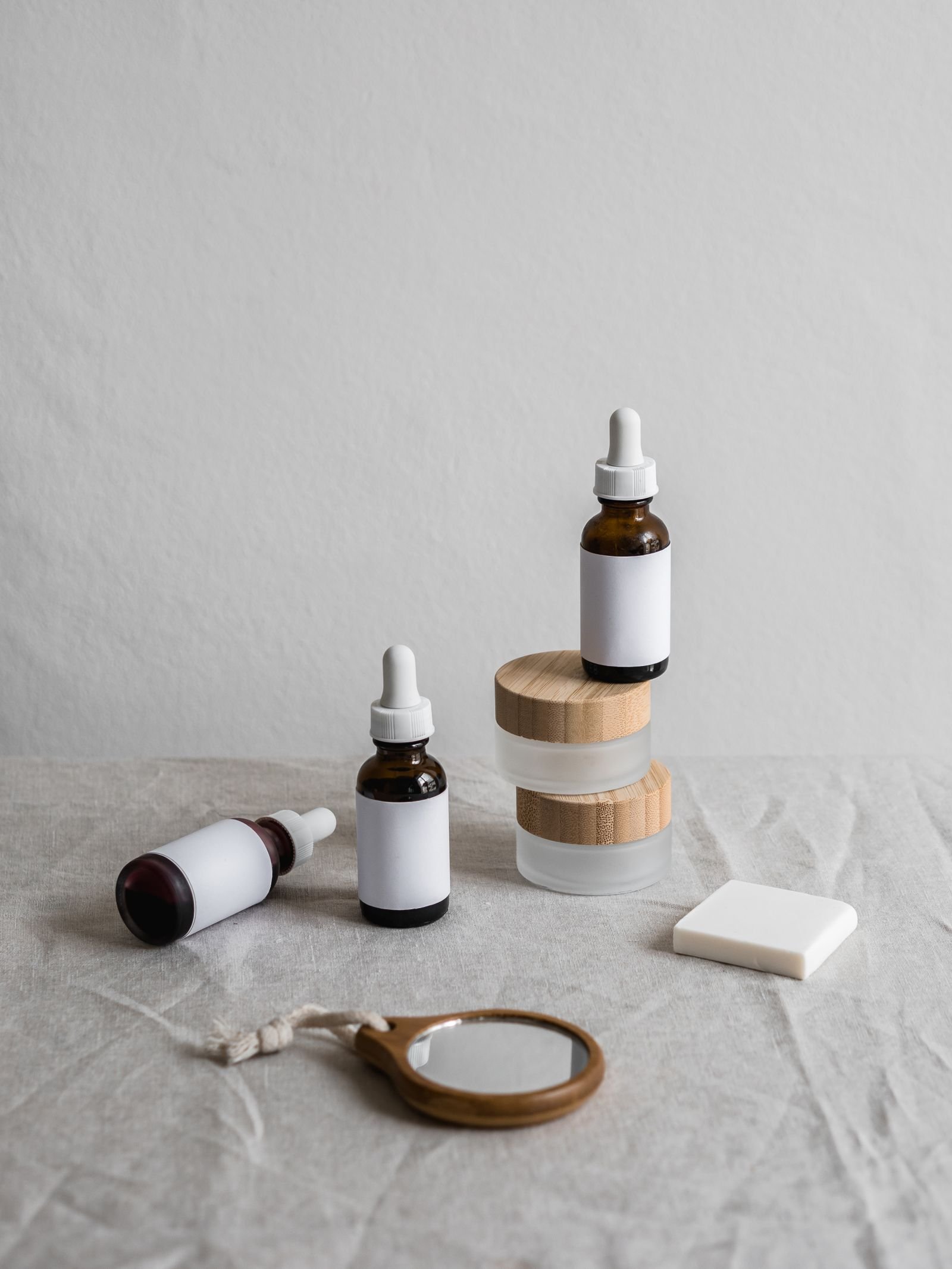 Skincare bottles arranged with wooden blocks on a pale surface
