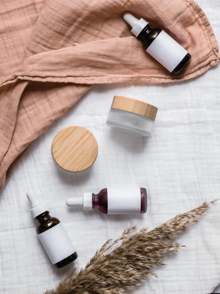 Cream jars with wooden lids on a folded linen throw in warm light