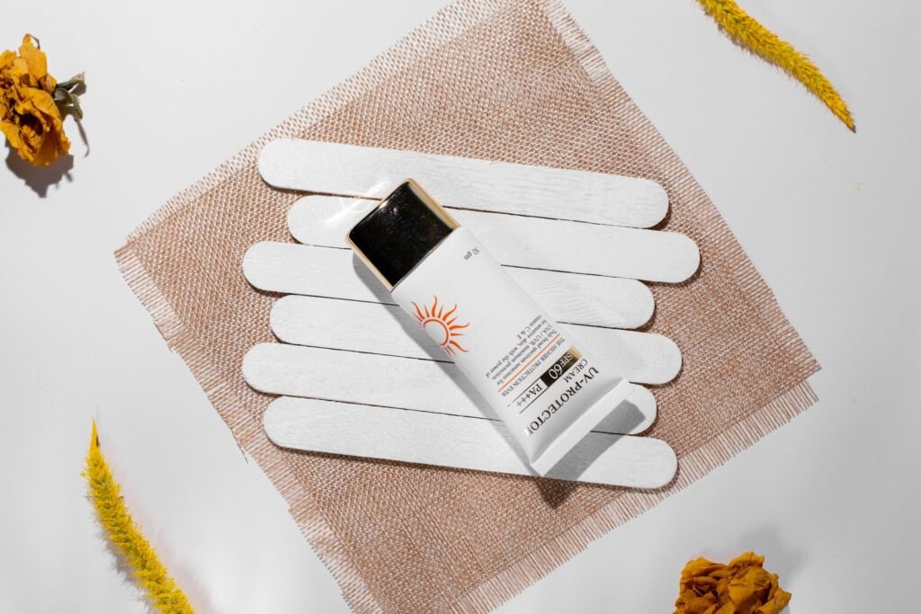 Sunscreen sticks and a tube arranged on a soft neutral cloth