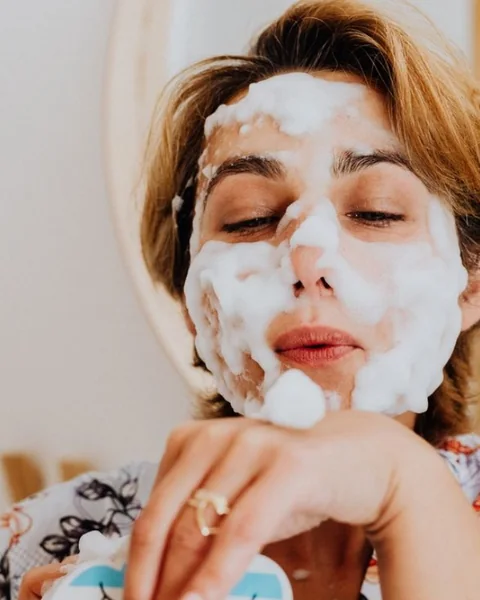 Woman washing her face with foaming cleanser