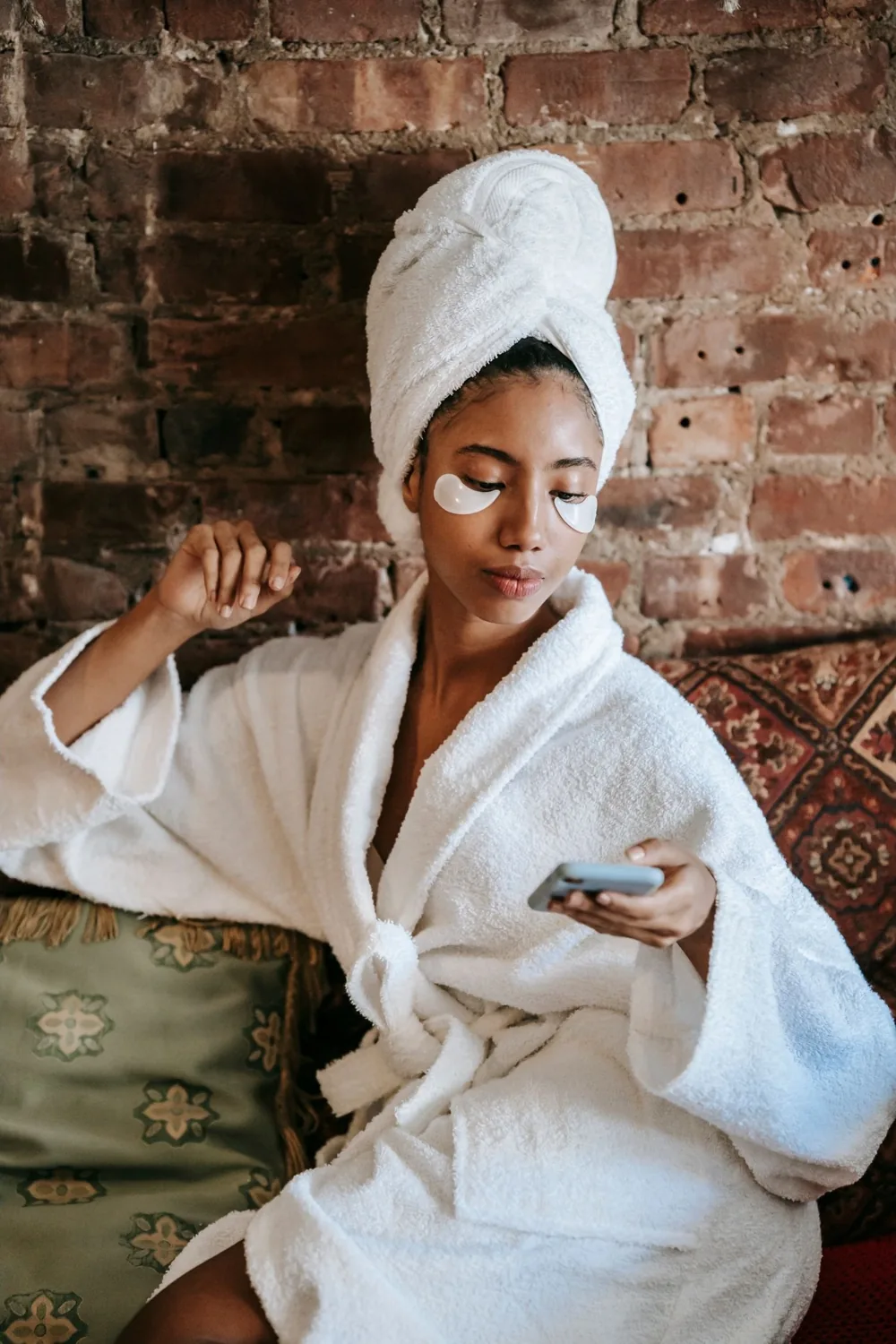 Woman in a towel wearing under eye patches